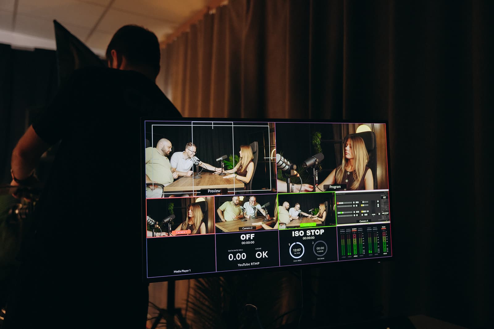 Realizator przy monitorze podglądu wielokamerowego — panel trzech osób
